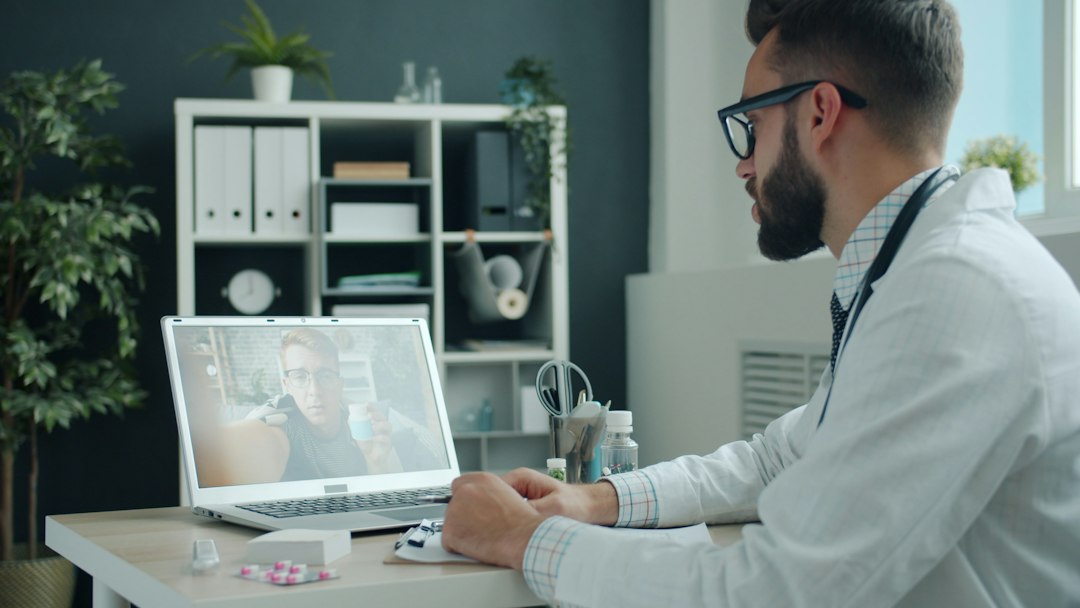Doctor consulting patient via video call on laptop