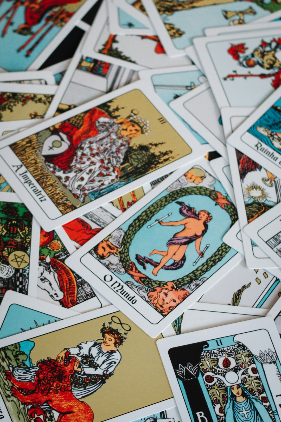 A pile of scattered tarot cards with colorful illustrations