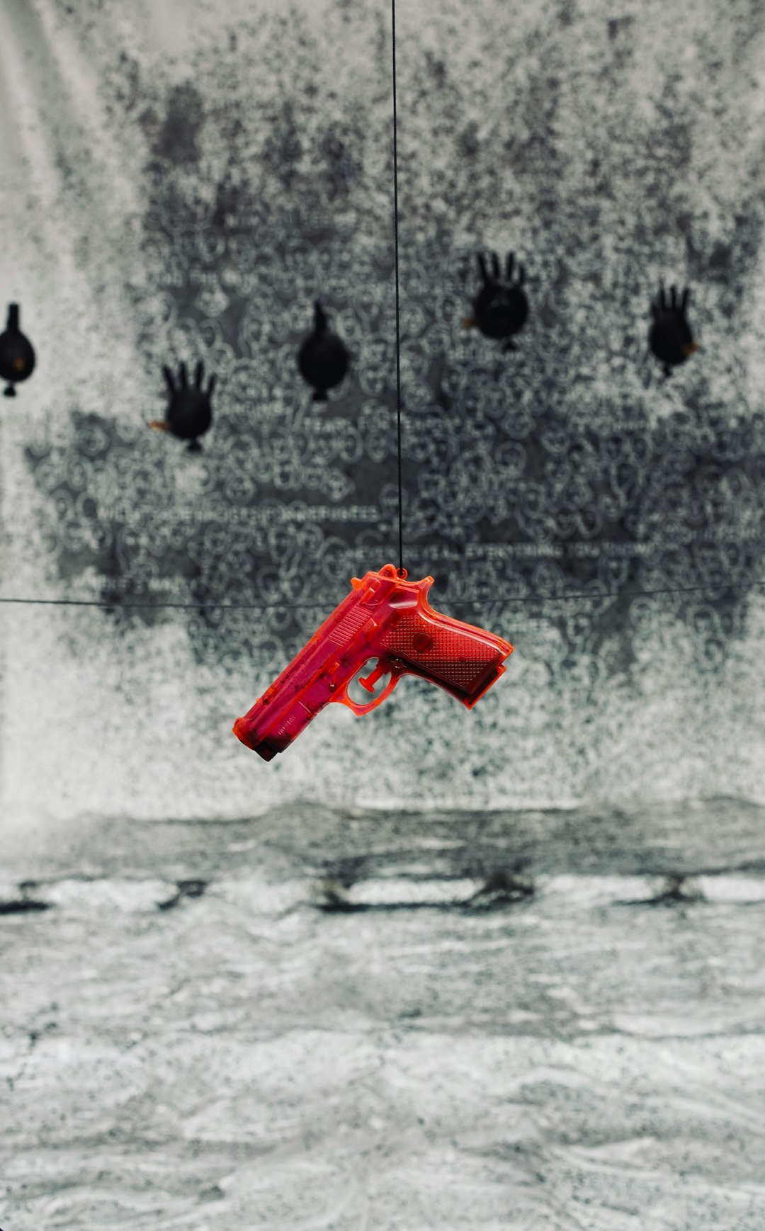 A red plastic gun hanging in front of a target